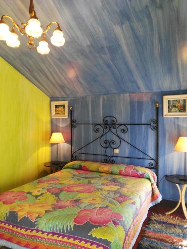 a bedroom with a bed with a painted ceiling at Posada Valle De Guriezo in Ríoseco