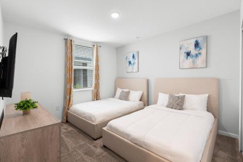 a bedroom with two beds and a tv in it at Paradise Home 20 Mins to Disney with Pool and Waterpark on Property in Abbeyville
