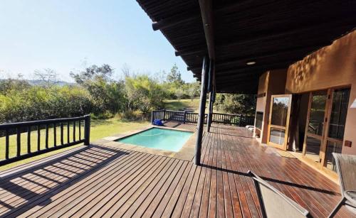 a wooden deck with a swimming pool on a house at Bush Willow Lodge in Hazyview