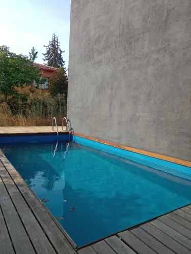 a swimming pool next to a concrete wall at Casa Negra in Moralzarzal