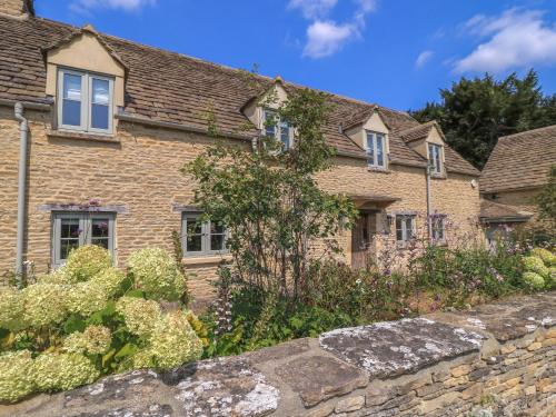 an old brick house with a stone wall at Easter Cottage in Burford