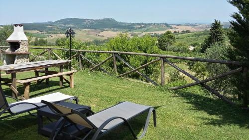 a picnic table and chairs in the grass with a view at Agriturismo Pescaia in Montepulciano