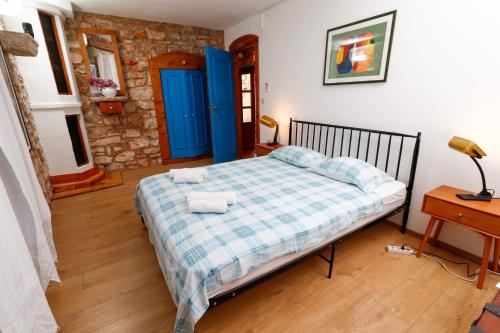 a bedroom with a bed with blue doors and a table at George's rooms in Stari Grad