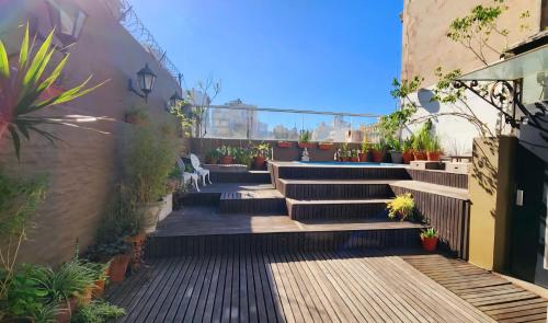 a garden with stairs and potted plants on a building at SanTelmo Casona Única 4Pisos Full Terraza Piscina Quincho Parrilla Ascensor 2Jacuzzis Sauna 7Dorm 6Baños in Buenos Aires