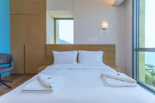 a bedroom with a large white bed with a window at Jounieh Living - Residences by Local Host in Ed Dkârîne