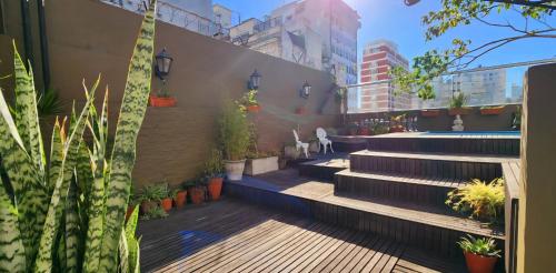 a garden with stairs and potted plants on a building at SanTelmo Casona Única 4Pisos Full Terraza Piscina Quincho Parrilla Ascensor 2Jacuzzis Sauna 7Dorm 6Baños in Buenos Aires