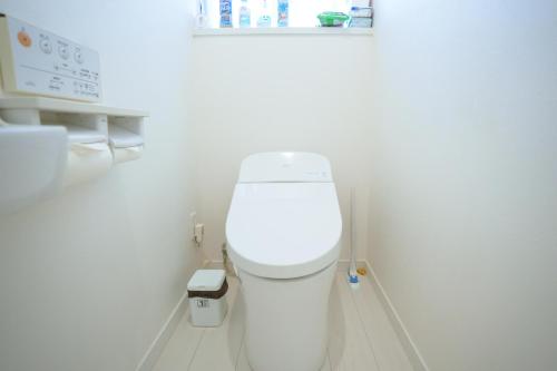 a bathroom with a white toilet in a white wall at -The Kabira- The closest private villa to Kabira Bay! Free car rental & BBQ in Ishigaki Island