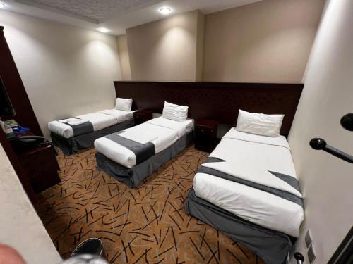 a room with two beds in a hotel room at فندق صفوة الخير المحبس الفندقية in Al Khansāk