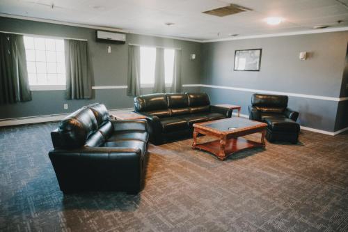 a living room with leather furniture and a coffee table at Queen City Inn in Bangor