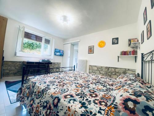 a bedroom with a bed with a floral comforter at Il mio accogliente giardino all' italiana in San Giovanni Valdarno