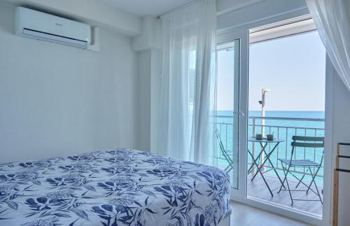 a bedroom with a bed and a balcony with the ocean at Amazing Oceanfront 2br in Oropesa del Mar