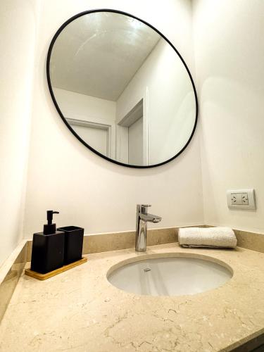 a bathroom sink with a large mirror on the wall at deptoquedateaqui in Olavarría