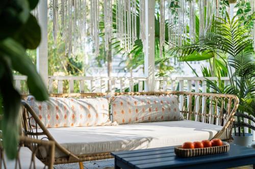a rattan couch in a room with plants at The Blue Bungalow - Peaceful, Porch, Hot Tub, Downtown in Orlando