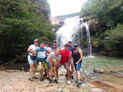 a group of people standing in front of a waterfall at hotel colonial la casona Mogotes in Estación El Salto