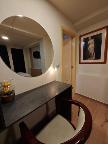 a room with a vanity with a mirror and a chair at Vymar and Loto Azul in Pasto