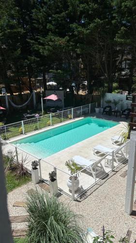 a swimming pool with two chairs and a table at Nereidas Apart in Mar de las Pampas