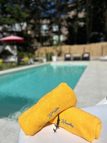 a yellow towel on a table next to a swimming pool at Nereidas Apart in Mar de las Pampas