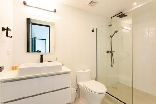 a bathroom with a toilet and a sink and a shower at Casco Viejo 2BR Loft - Rooftop Pool Gym & Balcony in Panama City