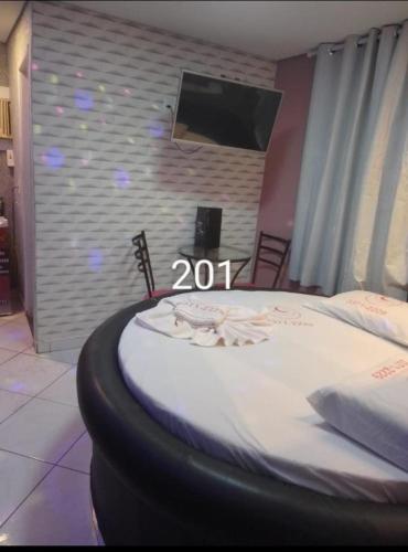 a bedroom with a bed with a sign that reads at Hotel 1001 noites ceilandia in Brasilia