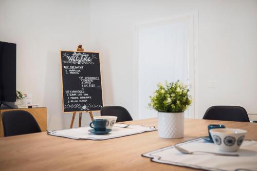 a table with two cups and a chalkboard at Zuara9Room Rimini in Rimini
