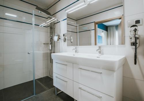 a bathroom with a sink and a shower at Hotel Radocza Park Business in Radocza