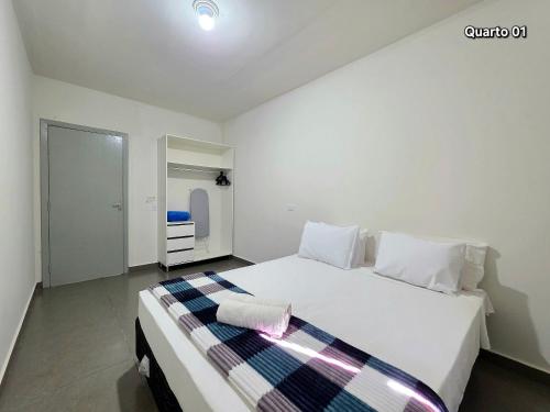 een slaapkamer met een groot wit bed in een kamer bij Casa 02 com 2 quartos, churrasqueira 15min centro in Foz do Iguaçu