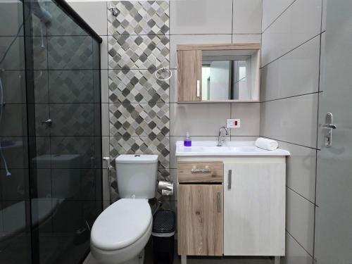 een badkamer met toilet, wastafel en douche bij Casa 02 com 2 quartos, churrasqueira 15min centro in Foz do Iguaçu