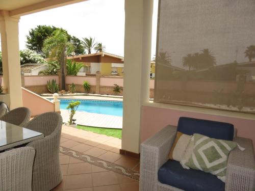 een patio met stoelen en een zwembad in een huis bij Villa Santa Bárbara en Isla Canela in Isla Canela