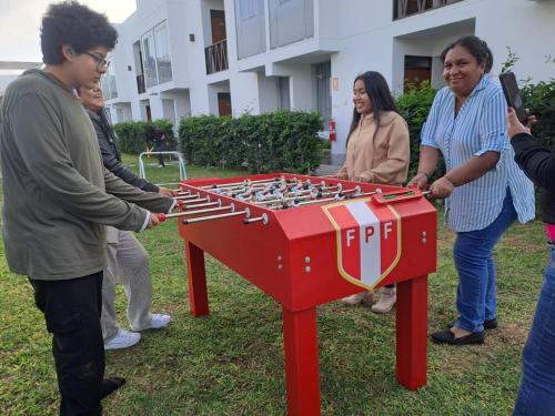 a group of people playing with a foosball table at Hotel Kendari - Chincha in Chincha
