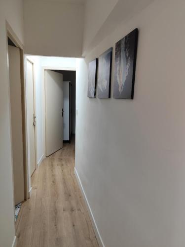 a hallway with three paintings on a wall and a hallway with a hallway at Maison En Centre Ville in Saint-Saturnin-lès-Avignon