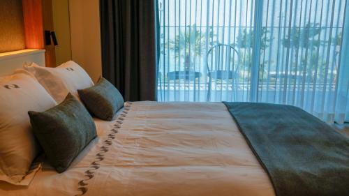 a bed in a hotel room with a large window at RUKA Hotel in Narlıdere