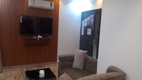 a living room with a chair and a tv at شقق لامير هوم للشقق المخدومة in Khamis Mushayt