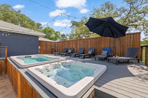 a hot tub on a deck with an umbrella at TX Sunset Ranch in Jonestown