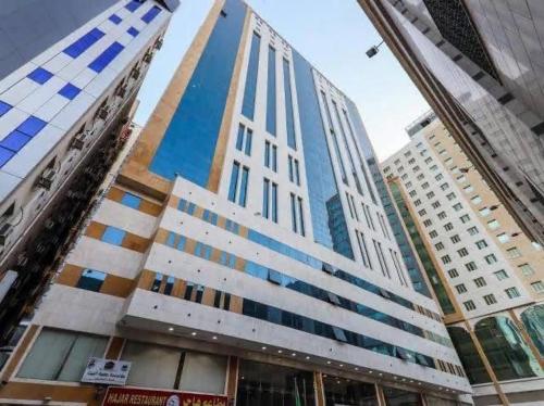 a tall building with blue windows in a city at فندق صفوة البيت المحبس الفندقية in Al Khansāk
