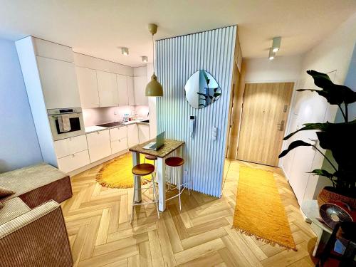 Una sala de estar con una mesa y una cocina. en Piltza House, en Cracovia