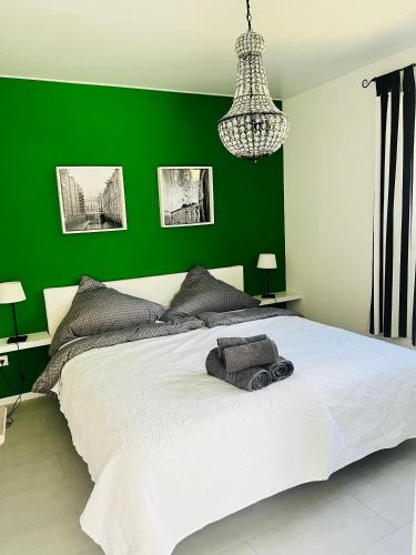 a green bedroom with a white bed and a green wall at Apartment im Grünen mit Stil in Mitterfels