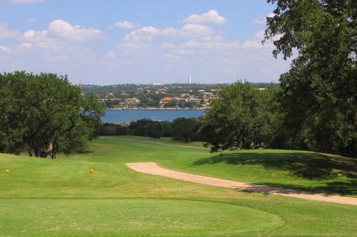 a golf course with a view of the water at Lago Vista Retreat in Lago Vista