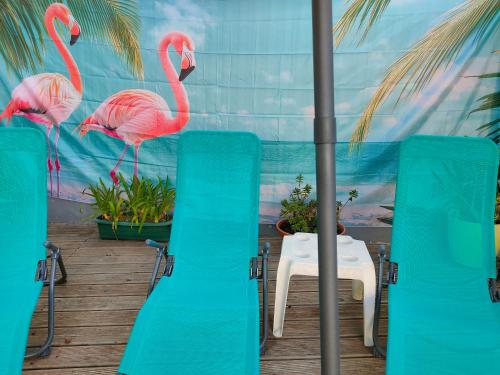 two pink flamingos standing next to chairs and a table at Vicentina Rooms by Casas do Alentejo in Almograve