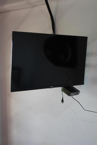a flat screen tv hanging on a wall at Hotel Curazao Natural Living cerca a charcos naturales y tobogán extremo in Cocorná