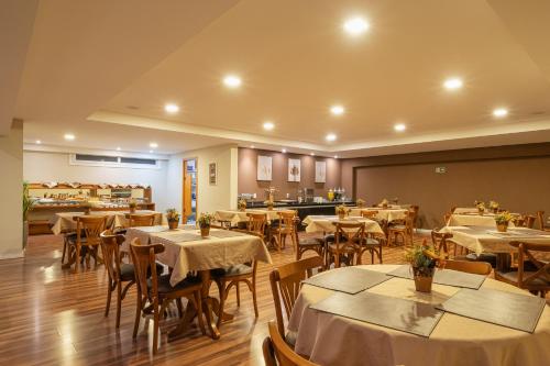 a restaurant with tables and chairs in a room at Hotel Querência in Gramado
