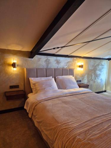 a bedroom with a large bed with two pillows at Maison Colombe, met airco in Oudesluis