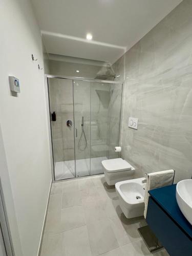 a bathroom with a shower and a toilet and a sink at Kupe Luxury Loft in SantʼAgata sui Due Golfi