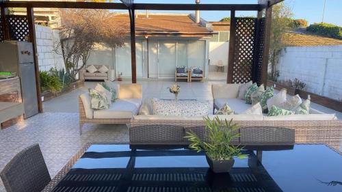 a patio with a couch and chairs on a patio at Casa desde la playa de cofradía de Algarrobo a el canelo in Algarrobo
