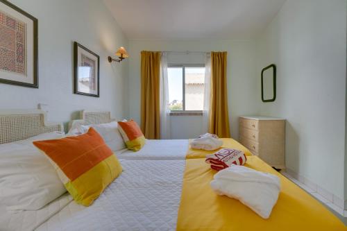 a bedroom with a large bed with towels on it at Muthu Clube Praia da Oura in Albufeira