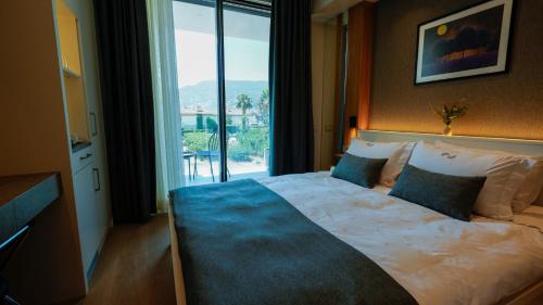 a bedroom with a bed with a large window at RUKA Hotel in Narlıdere