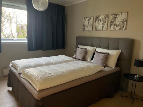 a bedroom with a large bed with white sheets and pillows at g-Suites in Tromsø