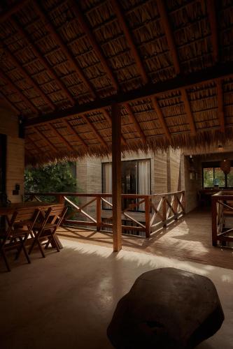 a large room with tables and chairs and a roof at Punta Tamarindo in Puerto Escondido