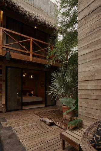 a house with a wooden deck with a bed at Punta Tamarindo in Puerto Escondido