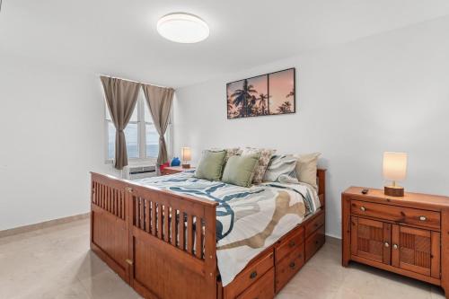 a bedroom with a wooden bed and a window at The Best View in Luquillo Beach Front View in Luquillo