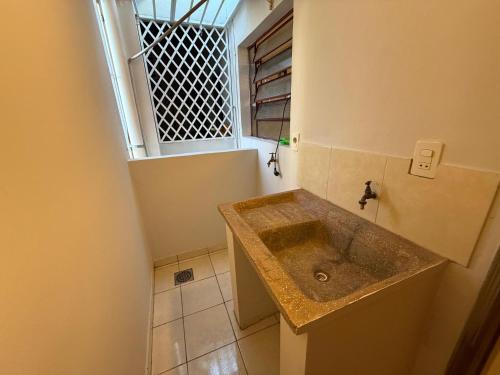 a bathroom with a sink and a window at Departamentos DE LA COSTA in Encarnación